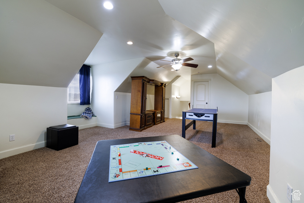 Playroom featuring dark colored carpet, lofted ceiling, and ceiling fan