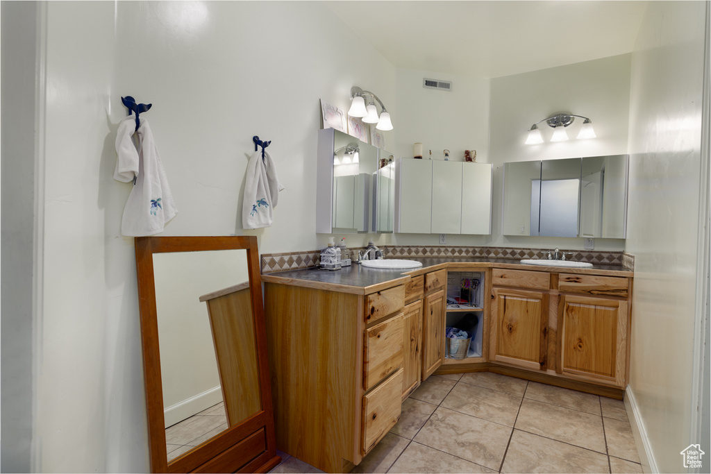 Bathroom with tile floors, oversized vanity, and dual sinks