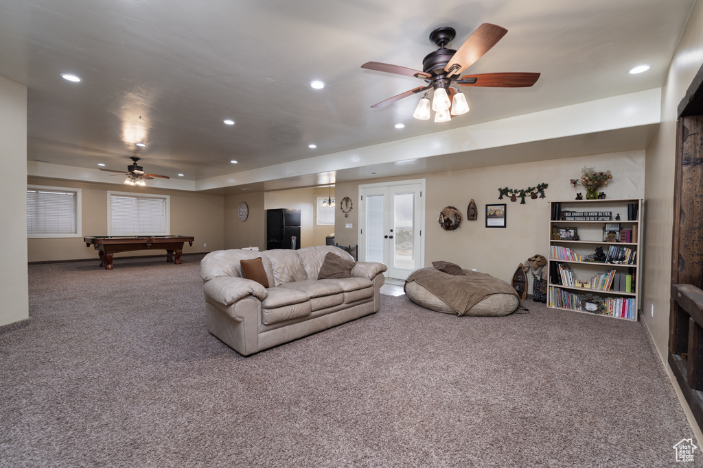 Carpeted living room featuring billiards, ceiling fan, and french doors
