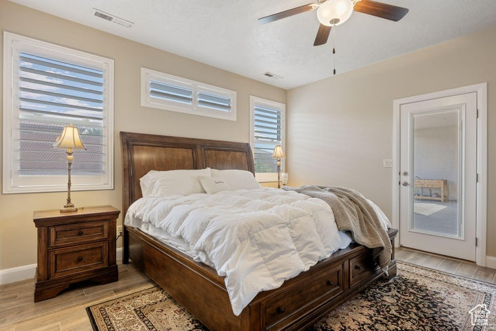 Bedroom with ceiling fan, access to exterior, and light hardwood / wood-style floors
