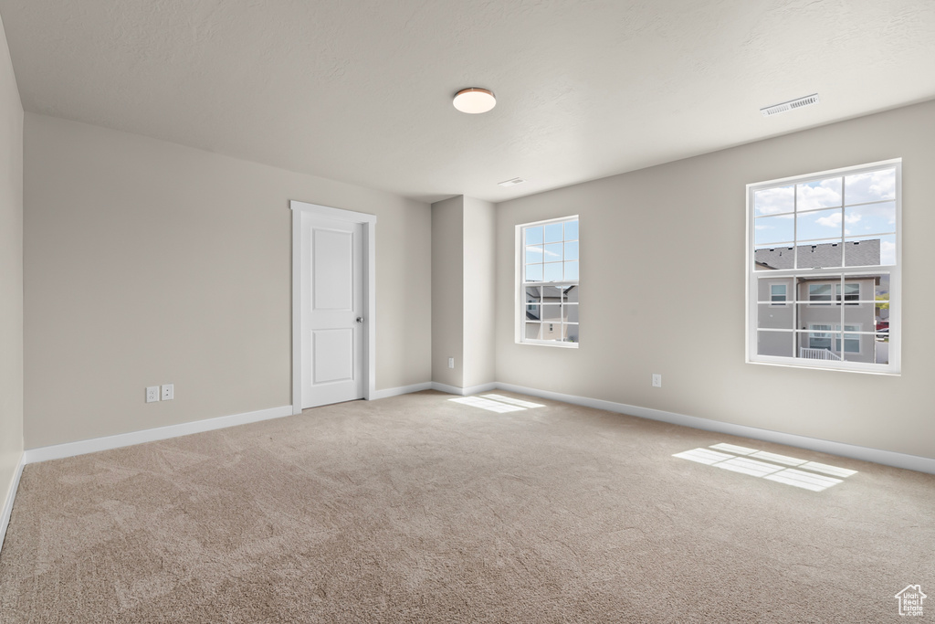 Carpeted empty room featuring a wealth of natural light