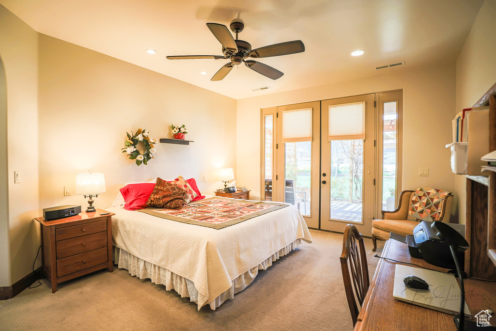 Carpeted bedroom with french doors, ceiling fan, and access to outside