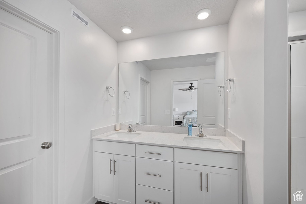 Bathroom featuring double sink vanity and ceiling fan