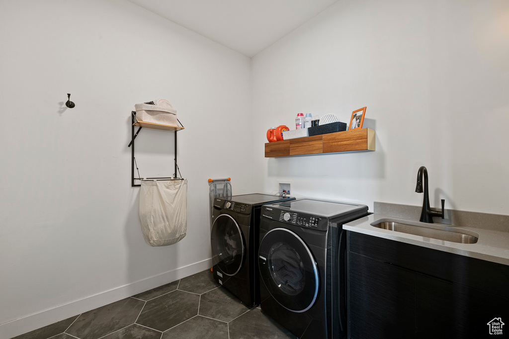 Washroom featuring washer hookup, sink, washing machine and dryer, and dark tile floors