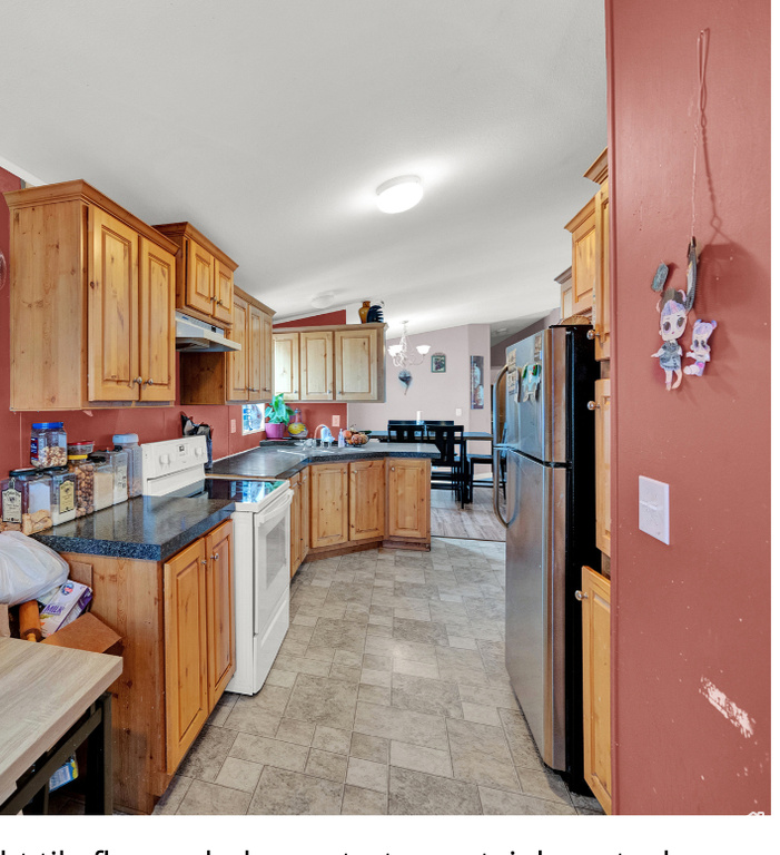 Kitchen with light tile floors, white electric range, and stainless steel fridge
