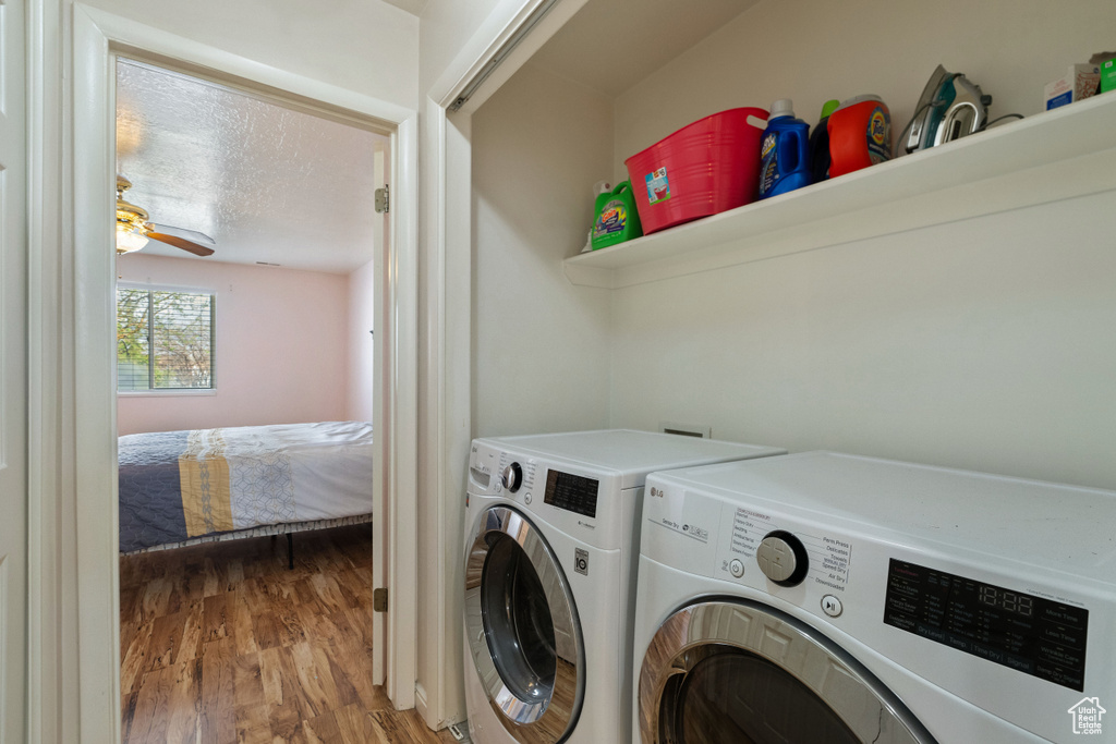 Laundry area featuring ceiling fan, washer and clothes dryer, and wood-type flooring