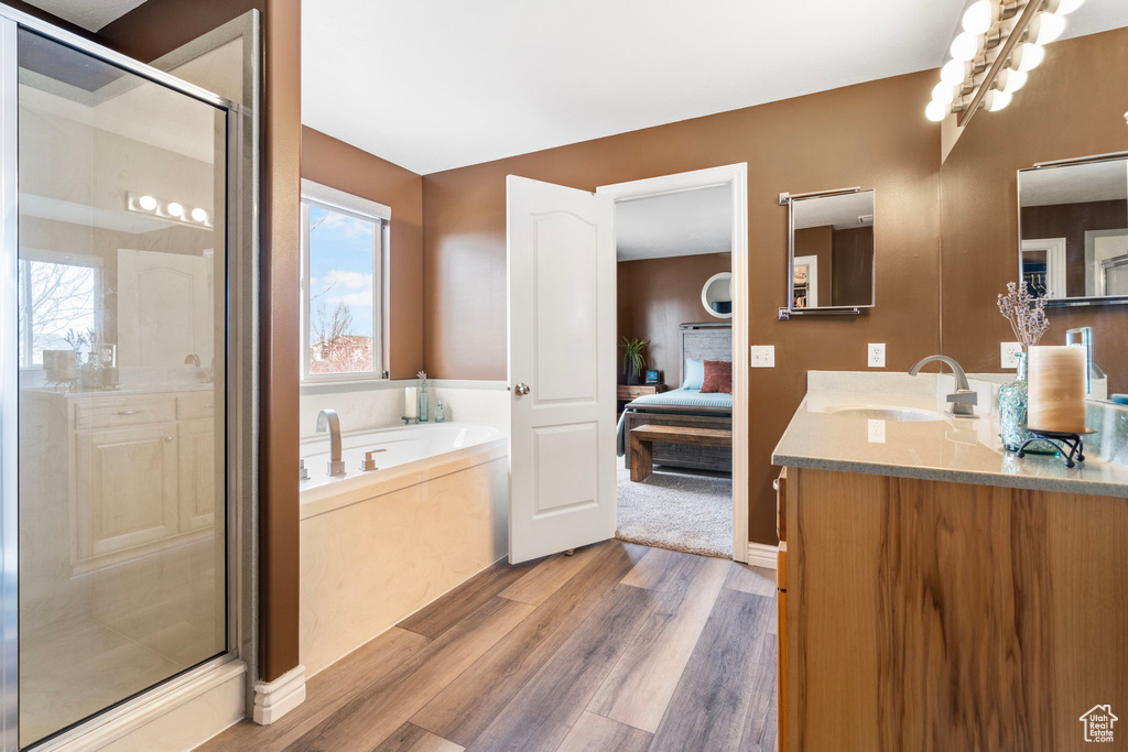 Bathroom with vanity, plus walk in shower, and hardwood / wood-style flooring