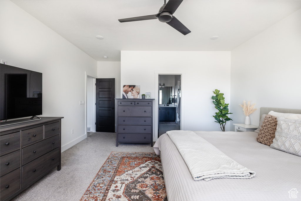 Bedroom featuring ceiling fan, light colored carpet, and connected bathroom