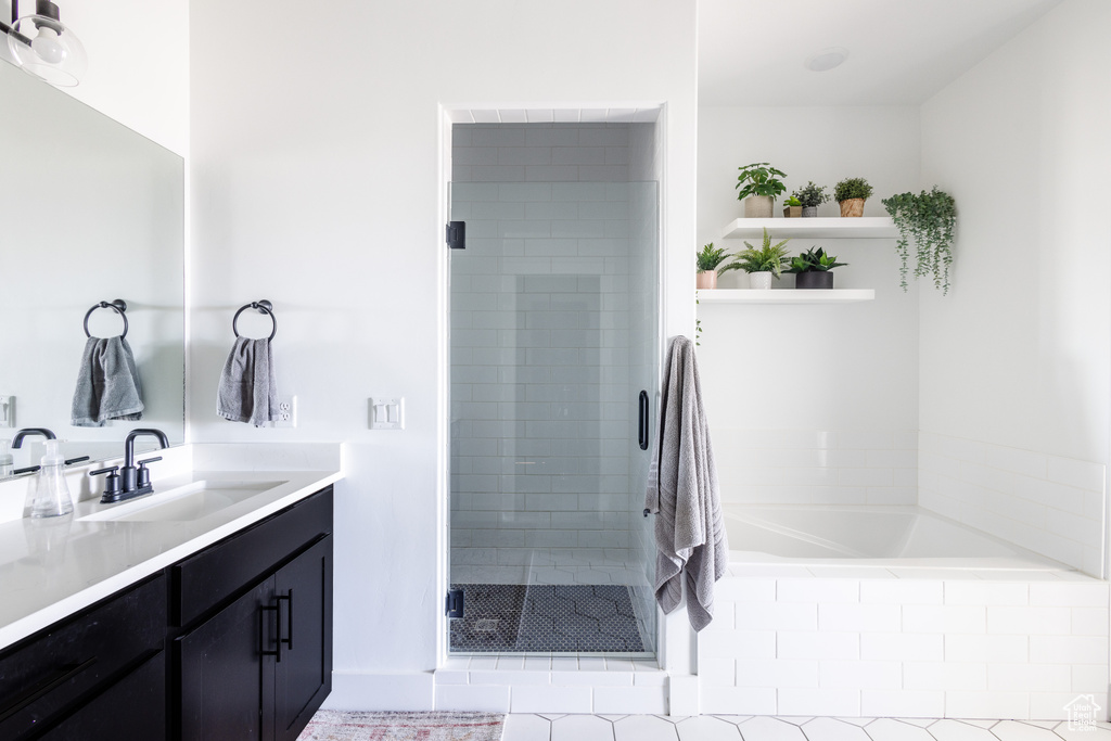 Bathroom with vanity, tile flooring, and shower with separate bathtub