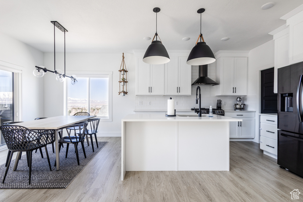 Kitchen featuring white cabinets, plenty of natural light, and backsplash