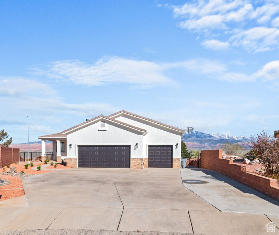 View of property exterior with a garage and a mountain view