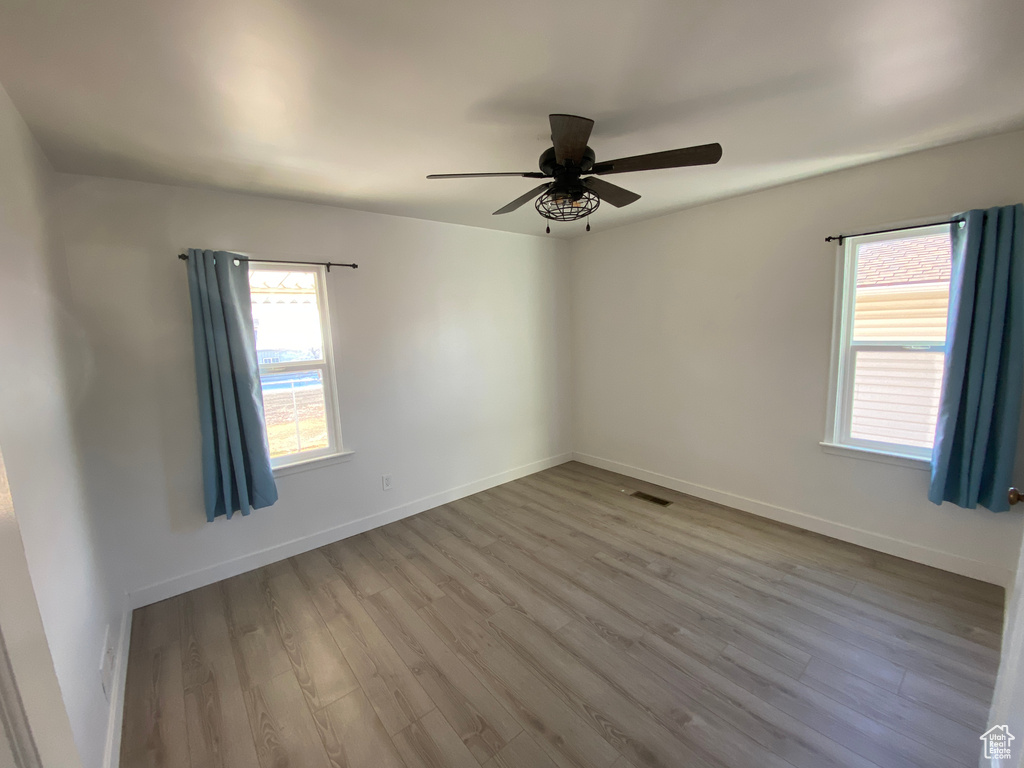 Empty room featuring light wood-type flooring and ceiling fan
