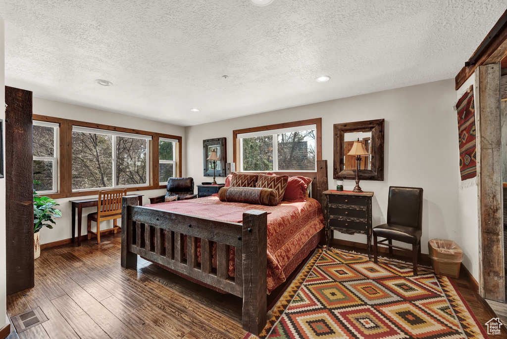 Bedroom featuring a textured ceiling and dark hardwood / wood-style flooring