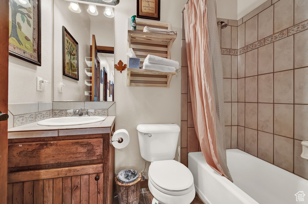 Full bathroom with shower / bath combo, vanity, and toilet