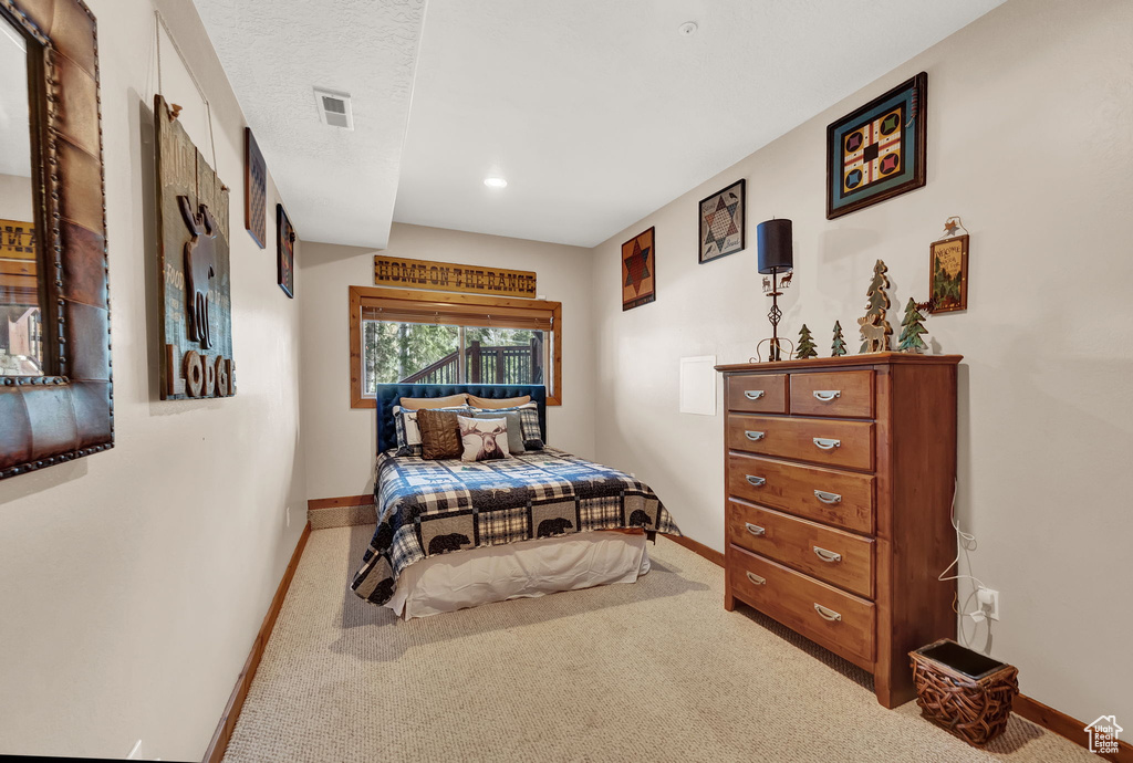 Bedroom featuring light carpet