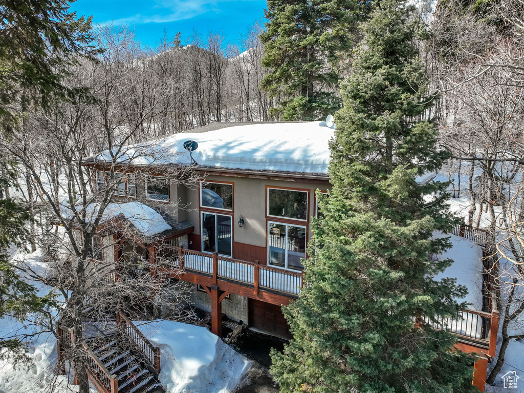 View of snow covered exterior with a deck