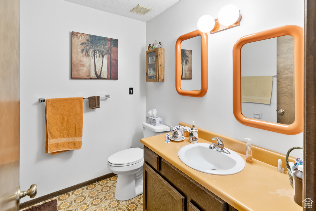 Bathroom featuring toilet, tile floors, and oversized vanity