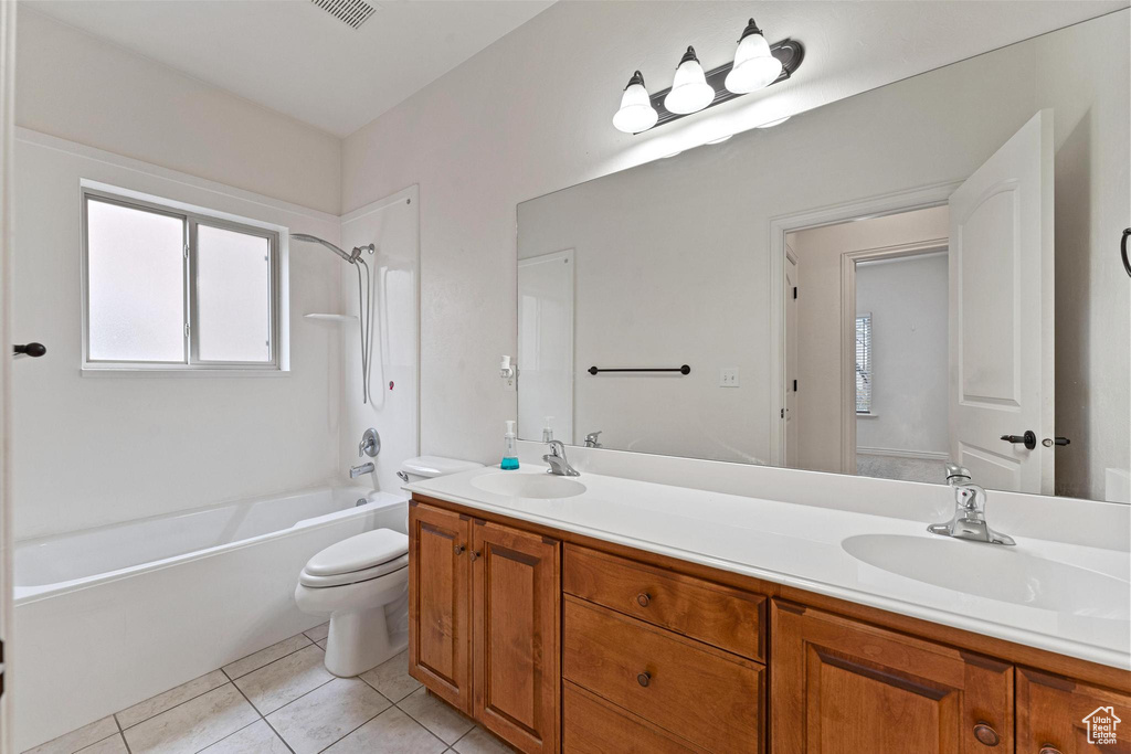 Full bathroom featuring toilet, shower / washtub combination, tile flooring, and dual vanity