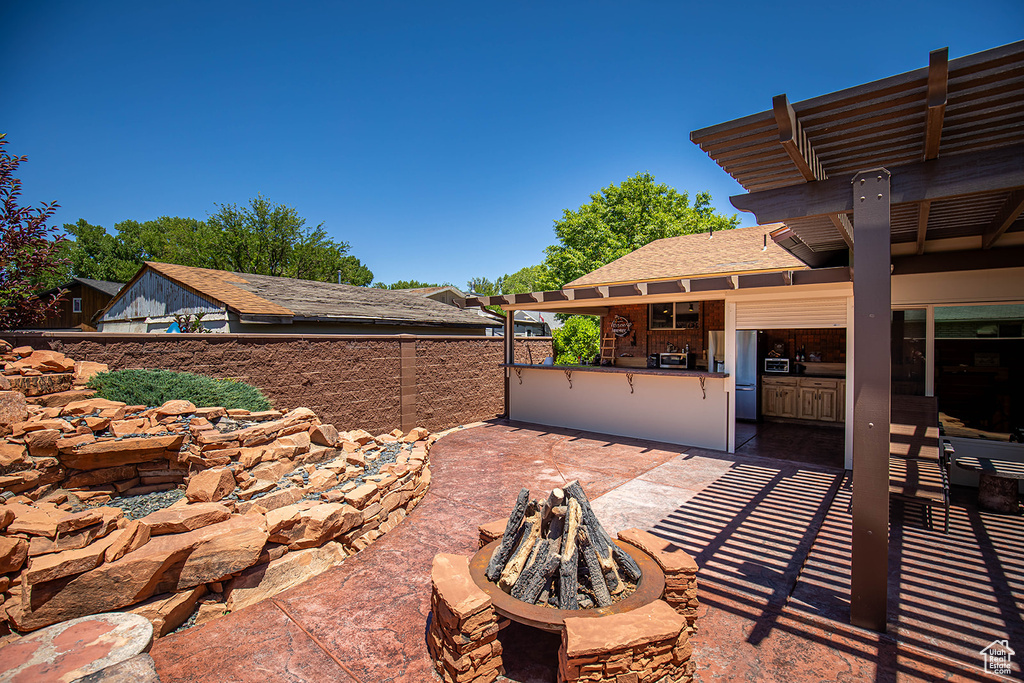 View of terrace with exterior kitchen and a fire pit