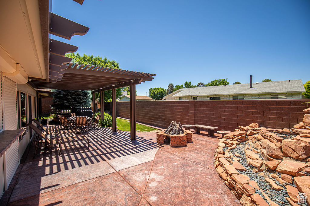 View of patio with a fire pit and a pergola