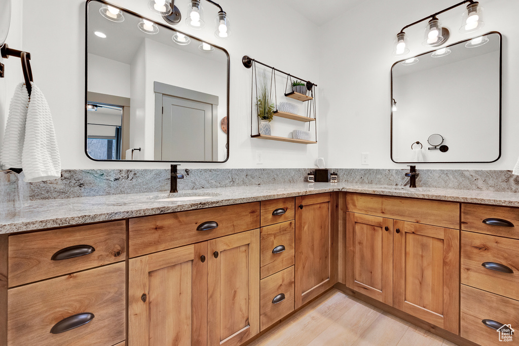 Bathroom with dual sinks, large vanity, and hardwood / wood-style flooring