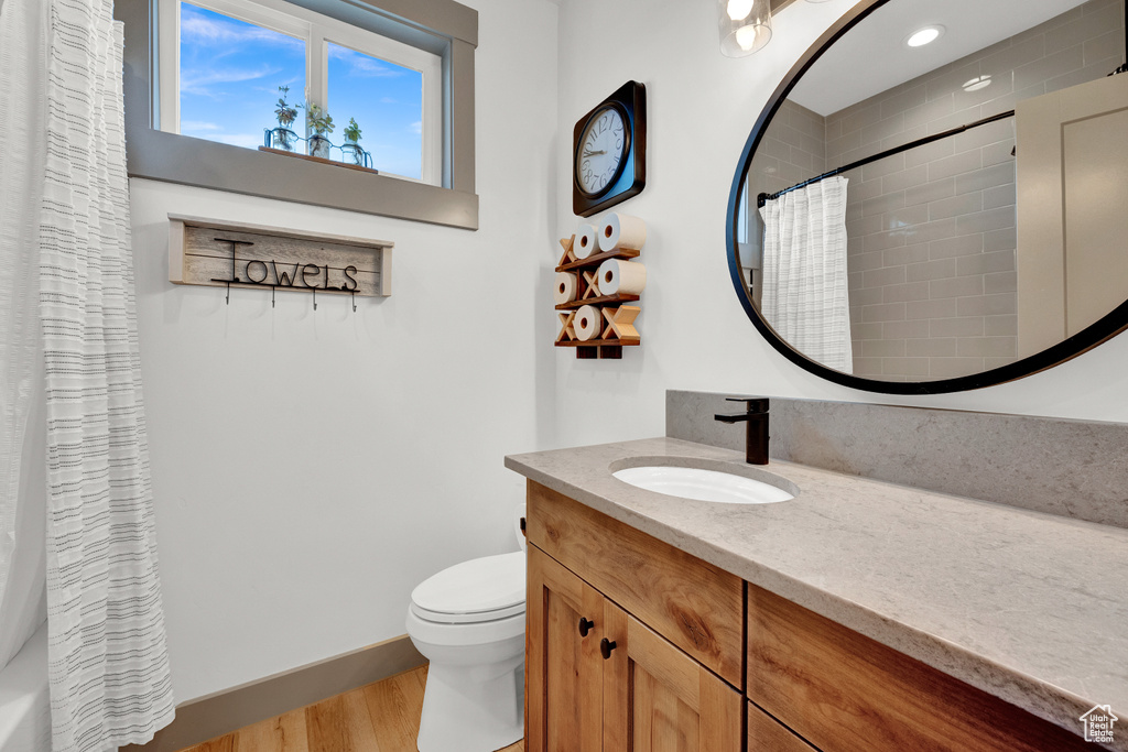 Bathroom featuring hardwood / wood-style floors, toilet, and oversized vanity