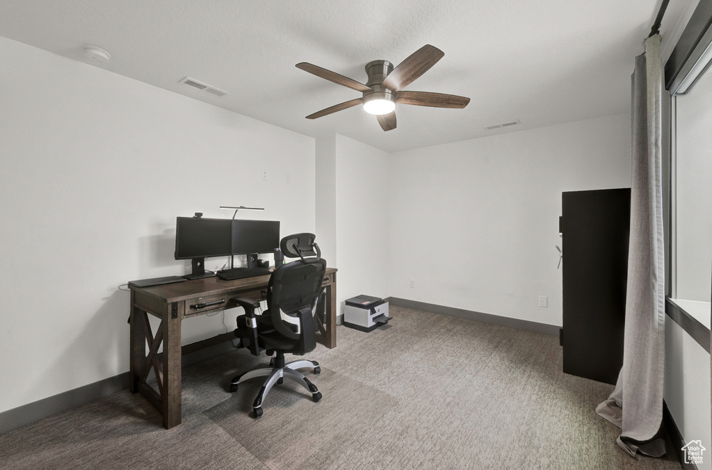 Office area featuring carpet floors and ceiling fan