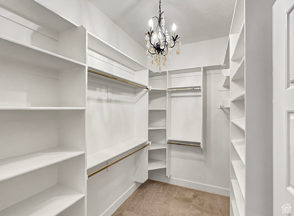 Walk in closet featuring a notable chandelier and light hardwood / wood-style floors