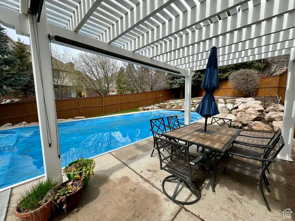 View of pool with a patio area and a pergola