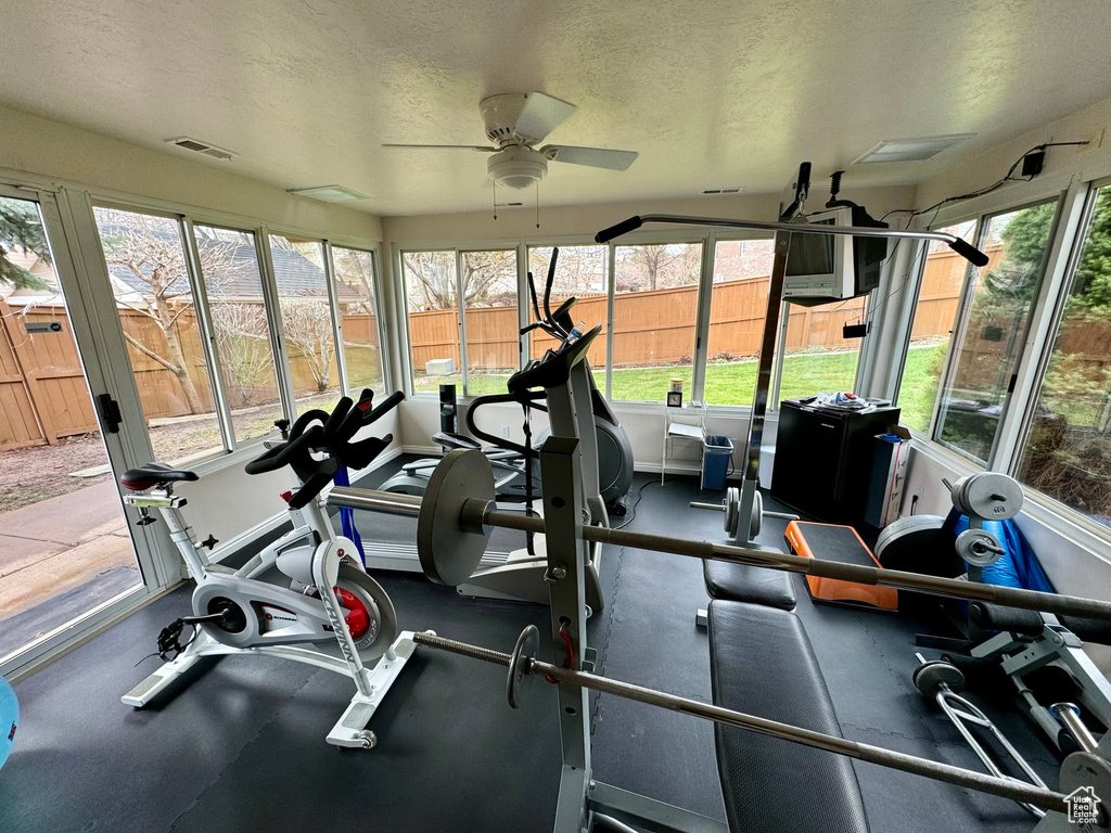 Workout area featuring plenty of natural light, ceiling fan, and a textured ceiling