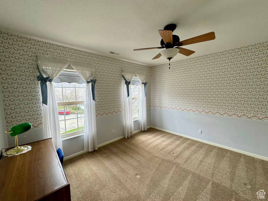 Interior space featuring light colored carpet and ceiling fan