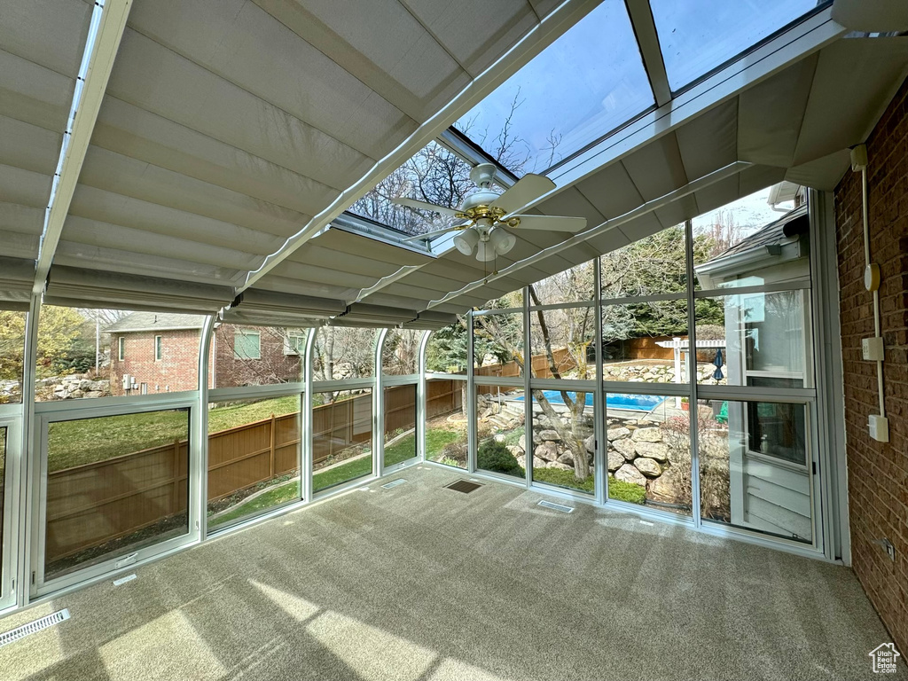 Unfurnished sunroom with a healthy amount of sunlight and ceiling fan