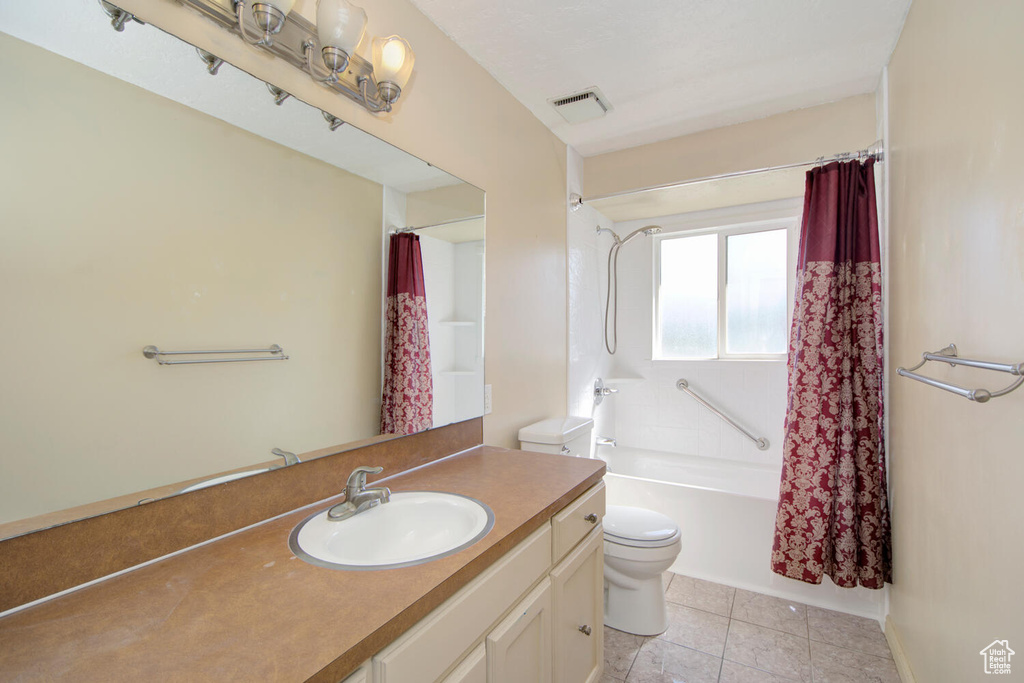 Full bathroom featuring shower / bathtub combination with curtain, toilet, tile floors, and oversized vanity