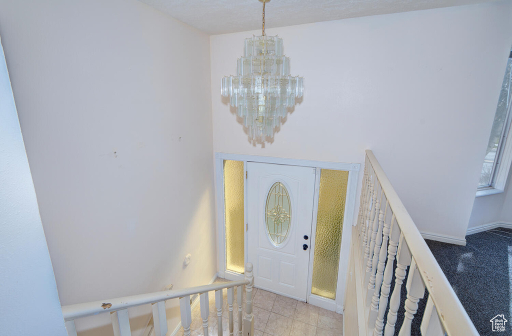 Foyer entrance featuring a chandelier and light tile floors