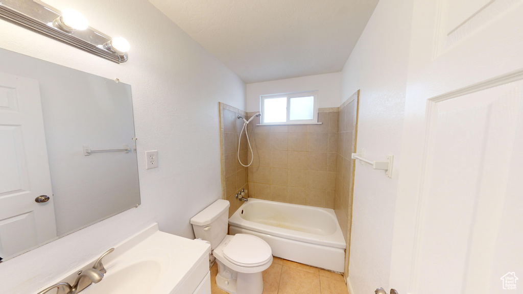 Full bathroom featuring toilet, vanity, tiled shower / bath combo, and tile floors