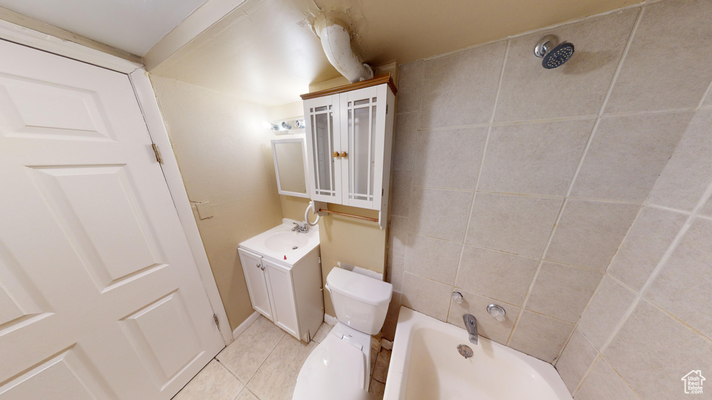 Full bathroom featuring tile flooring, vanity, toilet, and tiled shower / bath combo
