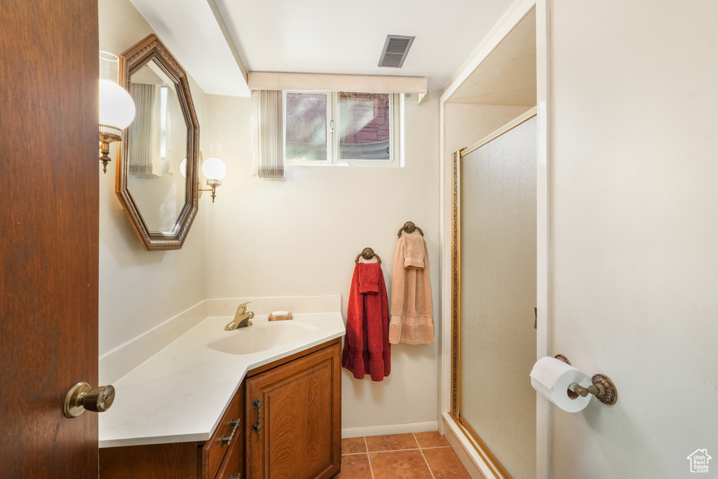 Bathroom featuring an enclosed shower, tile floors, and vanity