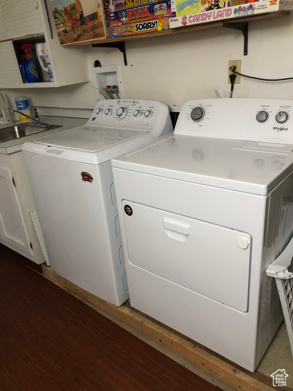 Laundry area with dark wood-type flooring and separate washer and dryer