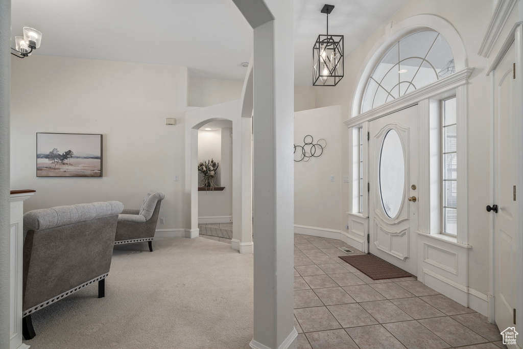 Entrance foyer featuring vaulted ceiling, an inviting chandelier, and light tile floors