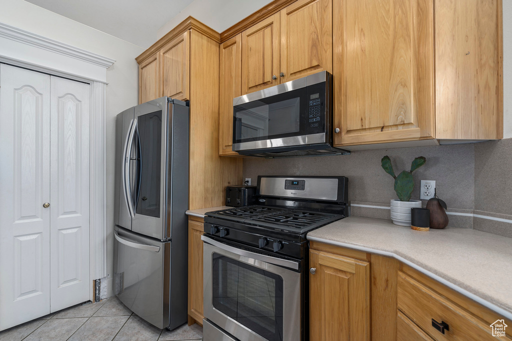 Kitchen featuring appliances with stainless steel finishes and light tile floors