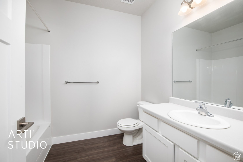 Full bathroom with shower / bathing tub combination, hardwood / wood-style floors, vanity, and toilet