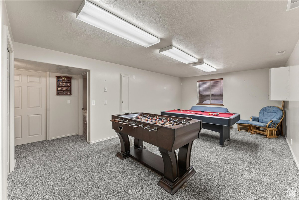 Game room with pool table, a textured ceiling, and carpet floors