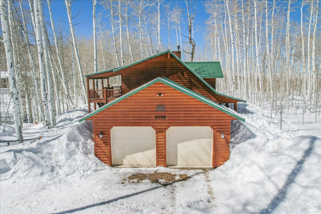 View of snowy exterior with a garage