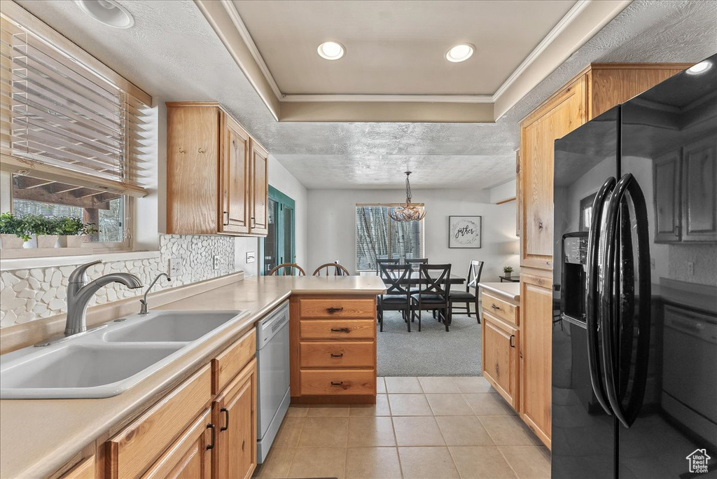 Kitchen with sink, decorative light fixtures, light tile floors, black refrigerator with ice dispenser, and dishwasher