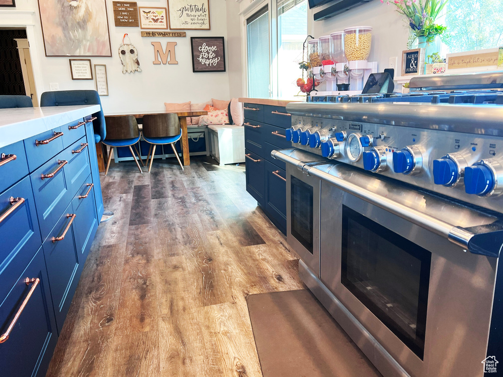 Kitchen with dark hardwood / wood-style flooring and blue cabinets