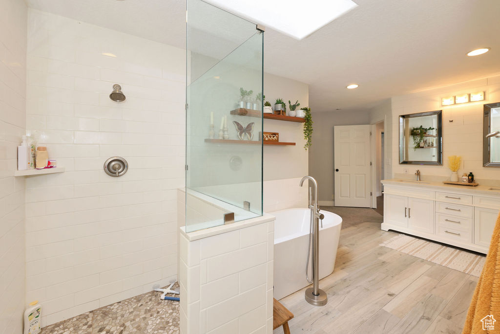 Bathroom with vanity, plus walk in shower, and hardwood / wood-style flooring