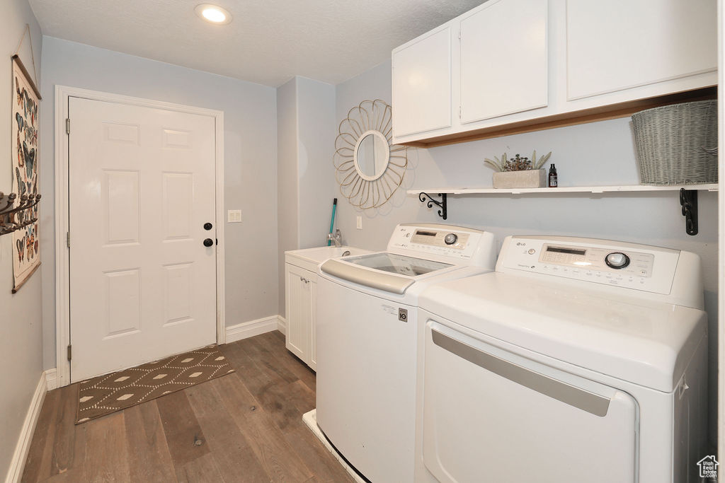Laundry area with cabinets, washing machine and clothes dryer, and dark wood-type flooring