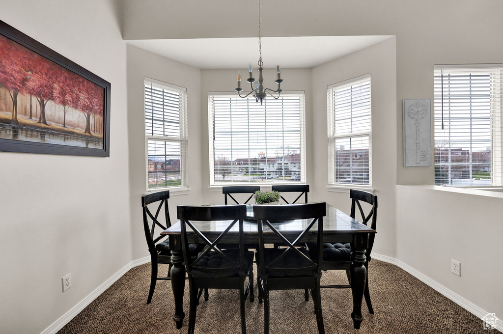 Dining space featuring a notable chandelier, carpet, and a wealth of natural light