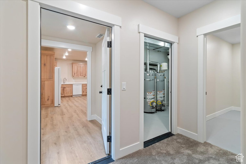 Hallway featuring water heater and hardwood / wood-style floors