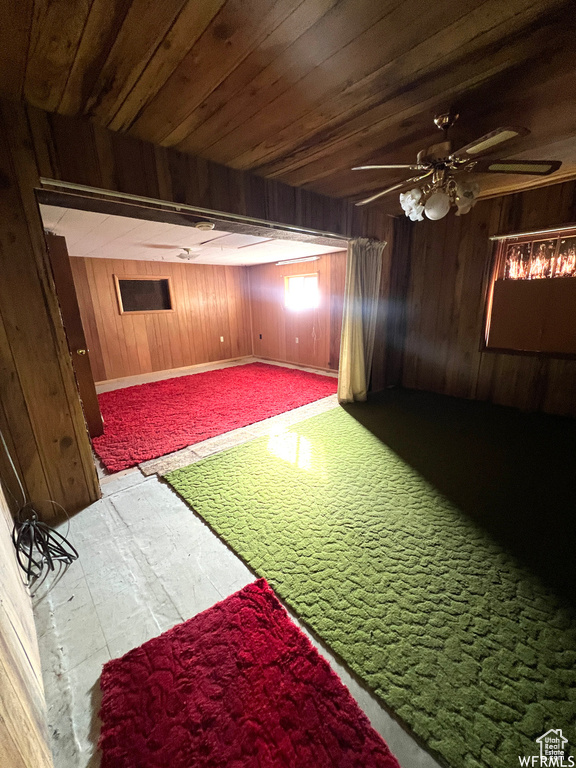 Unfurnished bedroom featuring light carpet, wooden walls, and wooden ceiling
